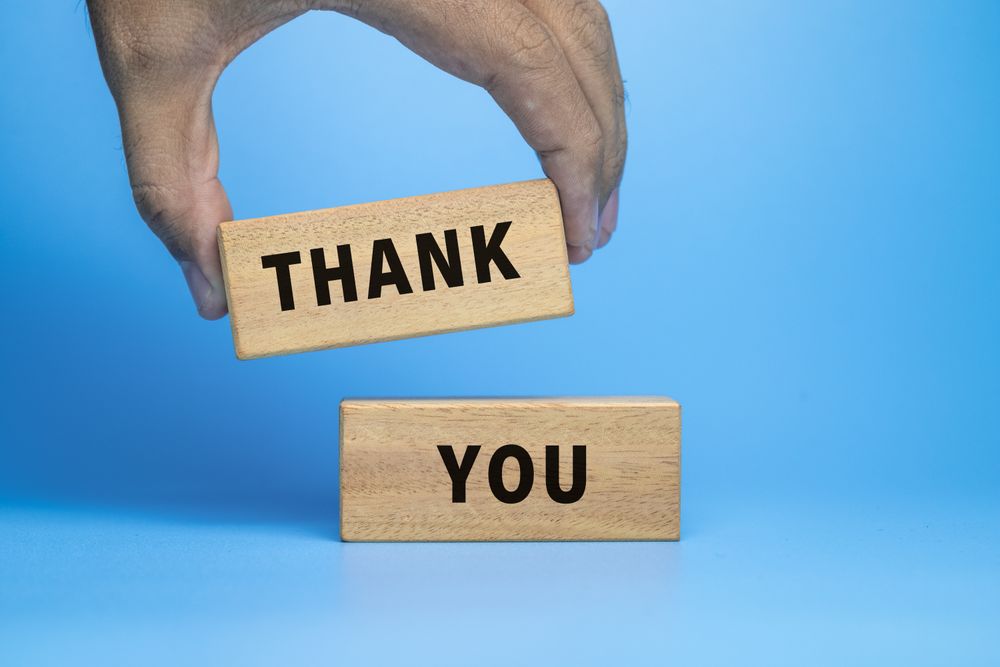 male hand putting thank words symbol on wooden blocks