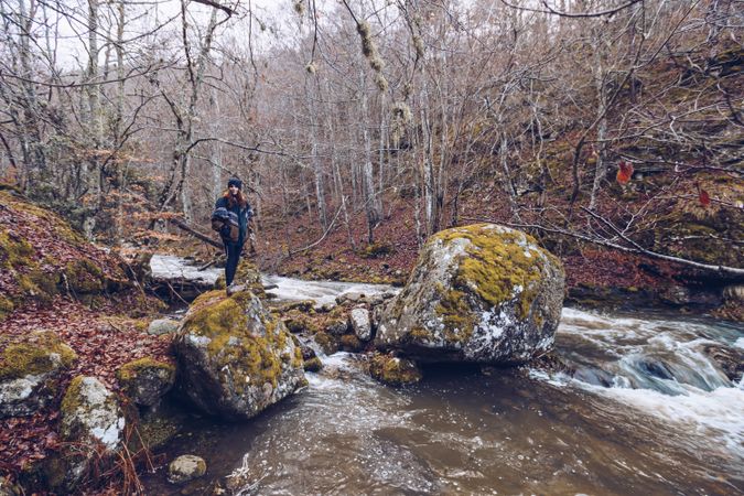 Female tourist standing on rock at autumn forest