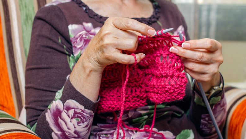 Hands of woman knitting a wool sweater
