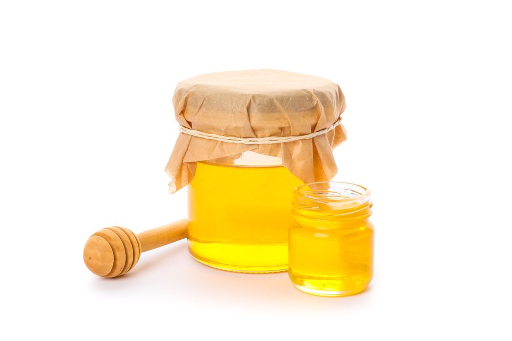 Dipper and glass jars with honey isolated on plain background