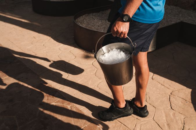 Person picking up bucket with ice