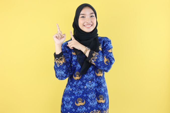 Indonesian teacher ASN or PNS in Batik Korri Pointing at Copy Space