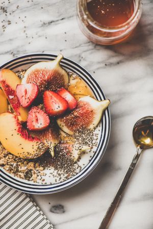 Flat-lay of yogurt bowl with fruit and honey