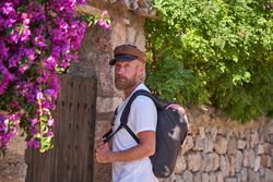 Male tourist with backpack exploring old town streets