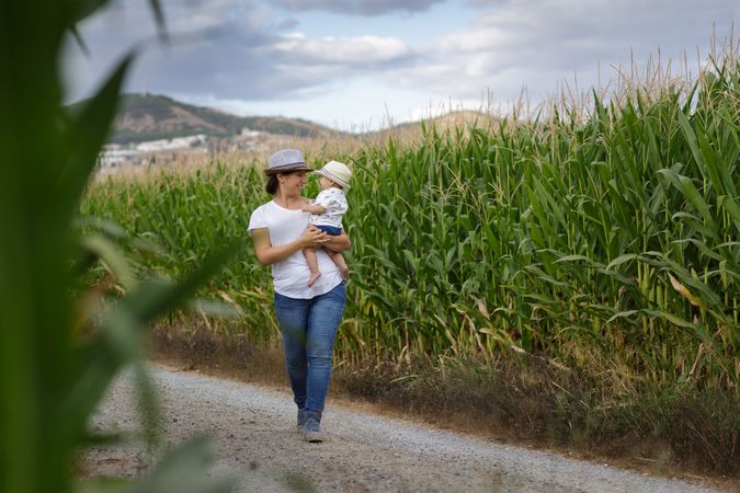 Adorable mother and child on hand enjoying and laughing in field