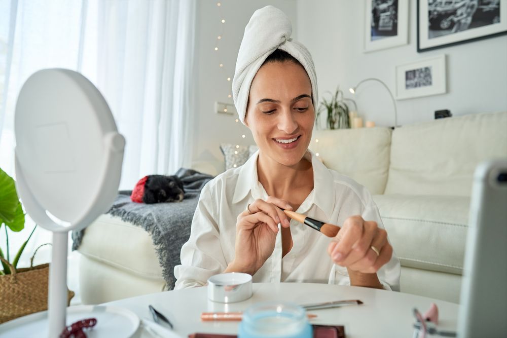 Smiling woman testing foundation on hand with brush