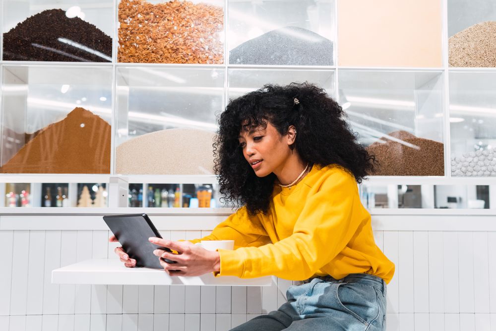 Black female using tablet against wall