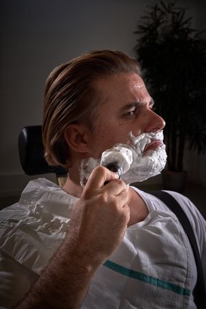 Man applying shaving foam in barbershop