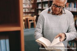 Older man checking for reference books in a university library 42g93b