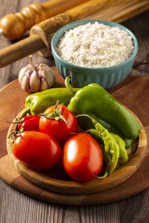Wooden table with ingredients for pizza.