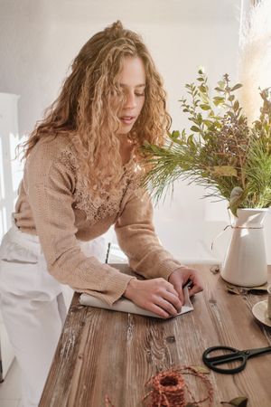 Focused woman wrapping gift in paper