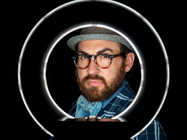Stylish man in elegant suit behind special circle light