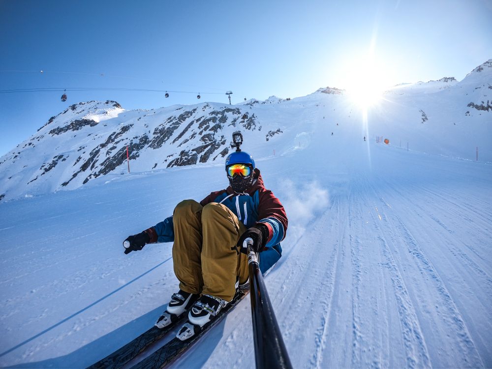 Man skiing on snow and taking selfie