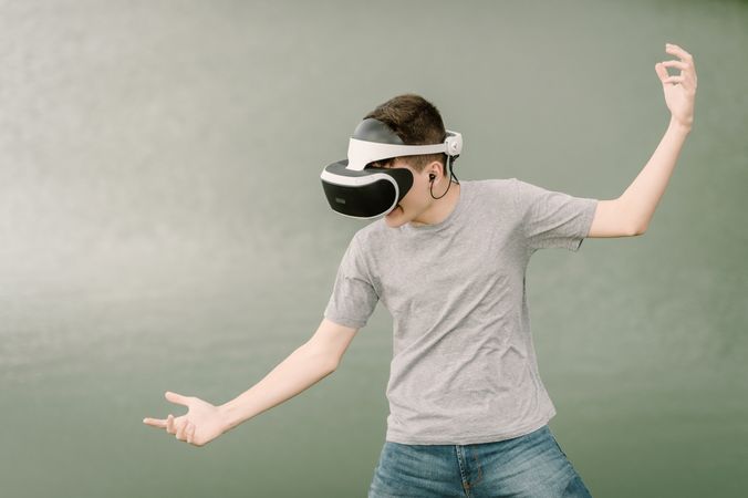 Young teenager with virtual reality glasses outdoors