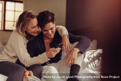 Cheerful man and woman looking at cell phone together 479A60