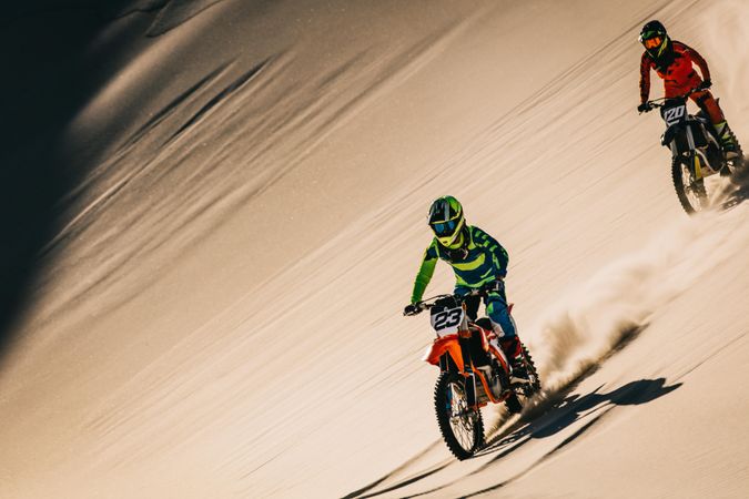 Motocross bike rider over sand dunes