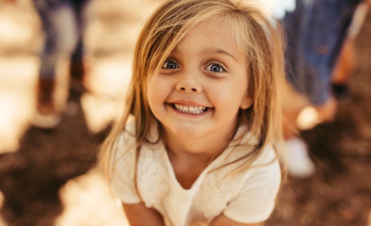 Girl child looking at camera with toothy smile