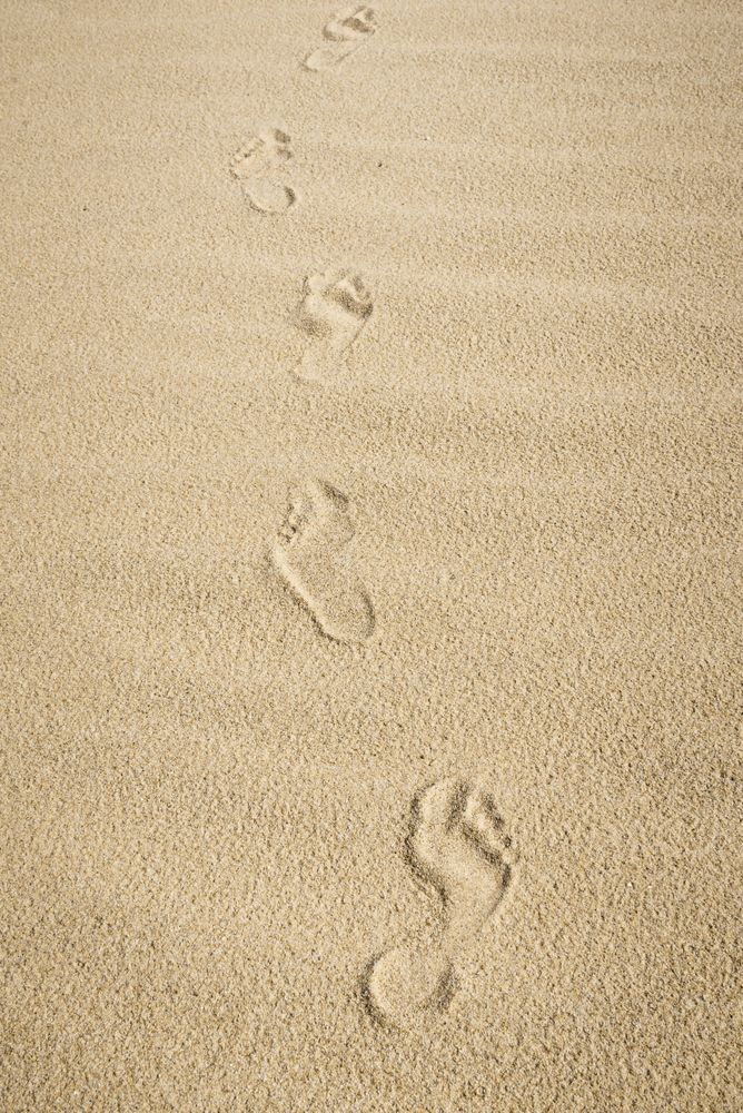Bare feet footprints on sand