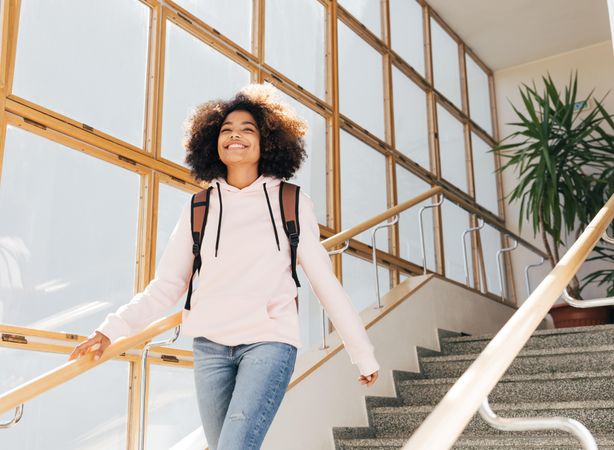 Teenage female student walking down stairs in school