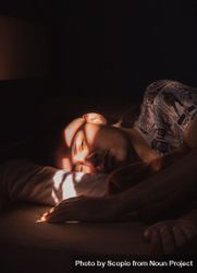 Man lying in bed resting with sun reflecting on his face 5QMon5