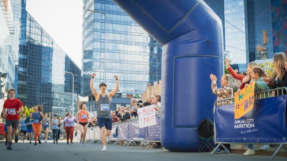 Portrait of Smiling  Man Running in a City Marathon, Waving at the Supportive Audience