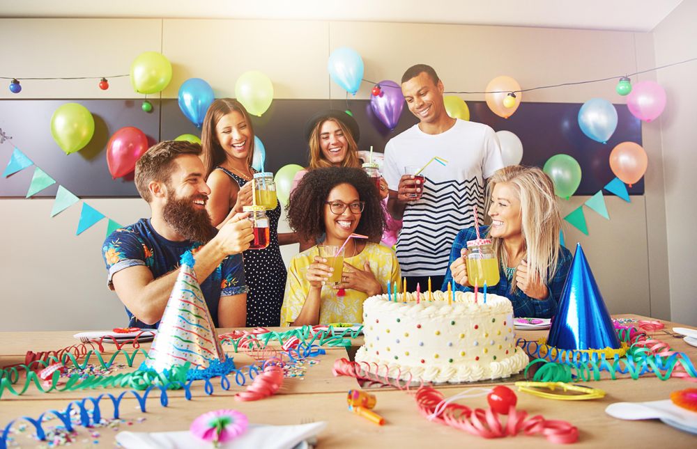 Multi-ethnic group of friends with drinks at a birthday party
