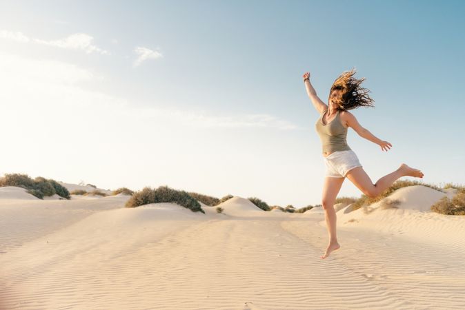 Active woman running in dry desert barefoot