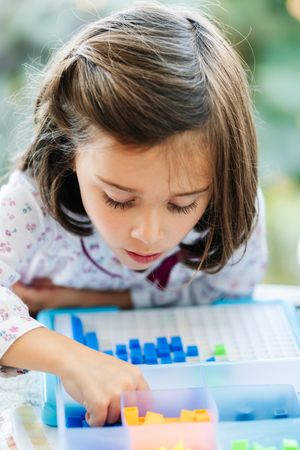 Girl playing with mosaic board game