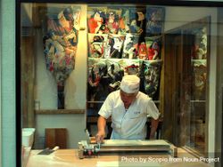 Man working in a shop with Chinese decoration 0VLxN4