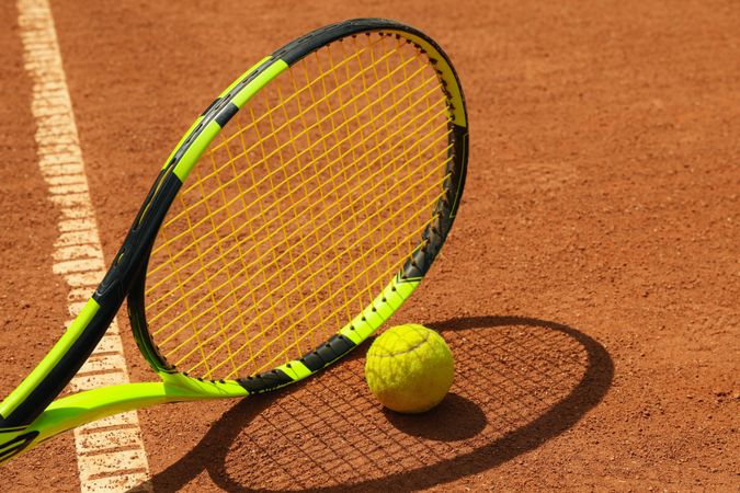 Tennis racquet and tennis ball on clay court