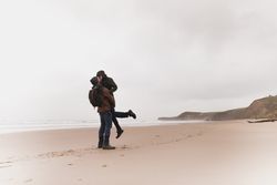 Couple kissing on sand shore near water
