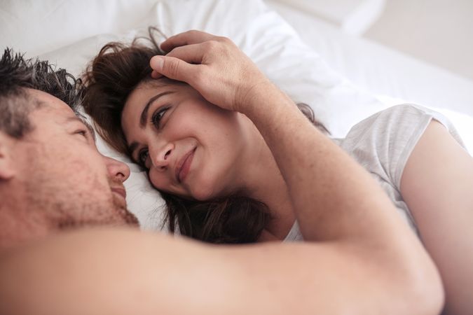 Man and woman looking at each other passionately in bed