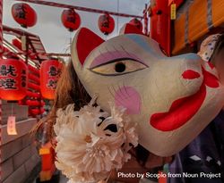 Person wearing Inari-Fox mask celebrating Motomiya-sai festival in Kyoto, Japan 4mwpz0