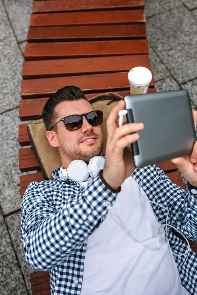 Young man using tablet outdoors