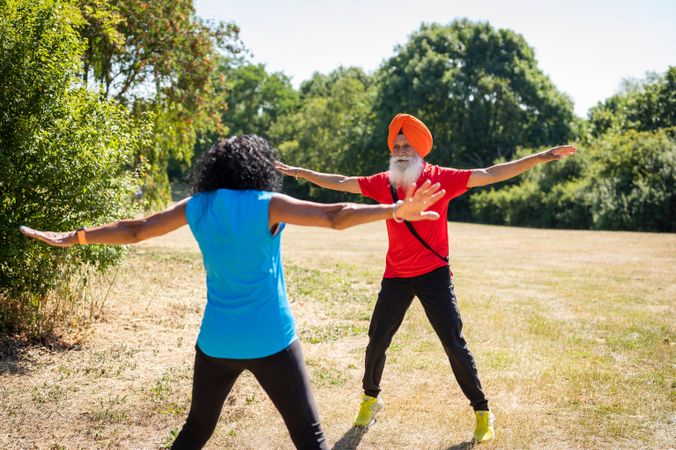 Mature Sikh couple doing jumping jacks