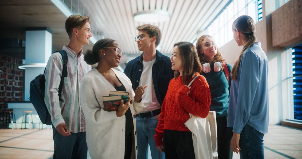Diverse Group of Students Engaging in a Lively Discussion in a Modern University Library.