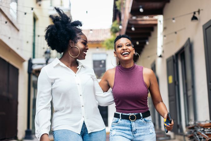 Black women laughing and having fun walking in the city