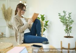 A beautiful woman sitting in the living room reading a book 4d61d0
