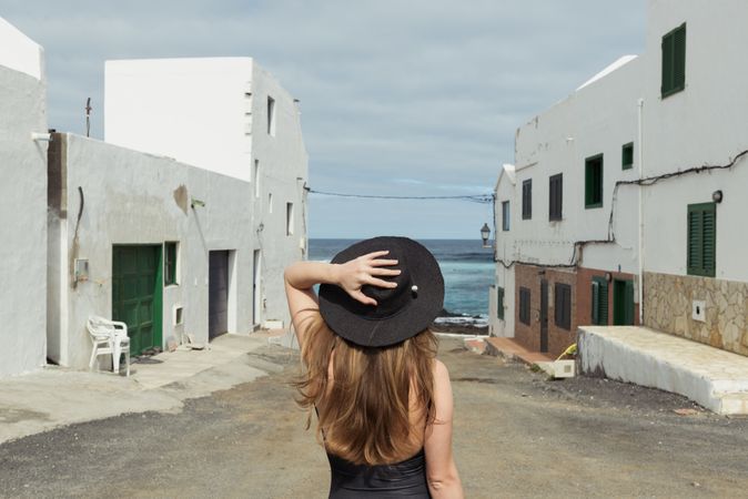Anonymous female on small street of coastal town