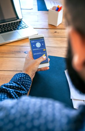 Businessman looking mobile with bitcoins information
