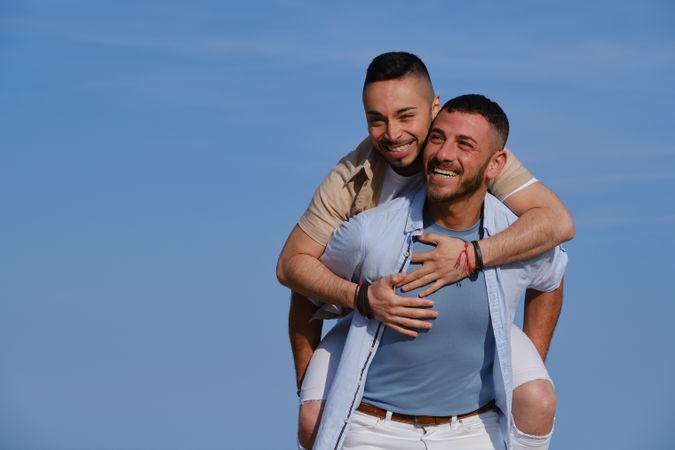 Happy gay couple playing piggyback
