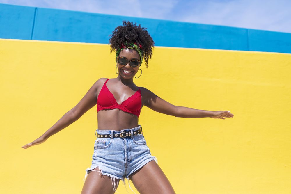 Fun Black woman dancing with arms outstretched