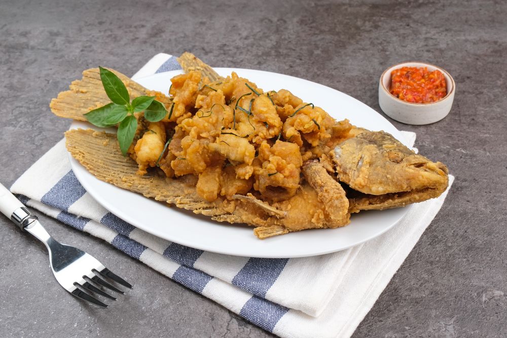 Gurame Saos Telur Asin. Crispy fried gourami fish covered with salted egg sauce. Indonesian food