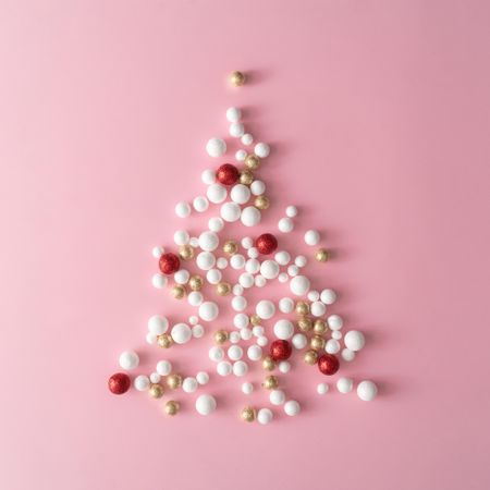 Christmas tree made of gold and red glitter ball decoration on pink background