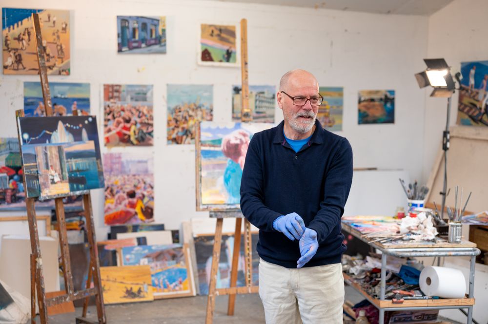 Male artist putting on protective gloves in art studio