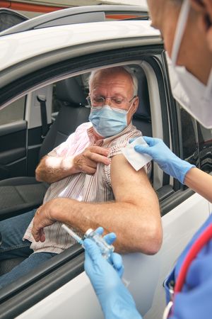 Crop nurse with vaccine preparing mature patient for inoculation