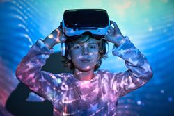 Adorable child taking off VR goggles and looking at camera again