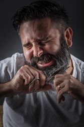 Expressive barber cutting beard