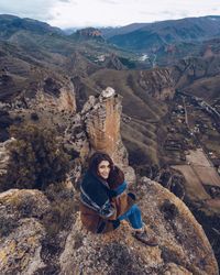 Cheerful woman resting on mountain top