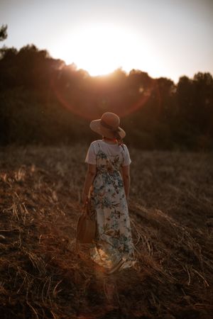 Anonymous woman walking in field
